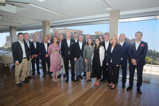 group of EMECA's General Assembly gathered for a photo in front of a large window