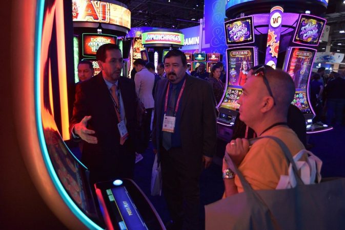 people in a casino in front of a slot machine talking