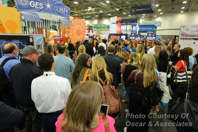 Photo of people gathered around a booth at a trade show event