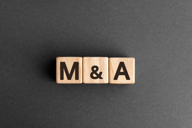 M&A - acronym from wooden blocks with letters, mergers and acquisitions M&A concept,  top view on grey background