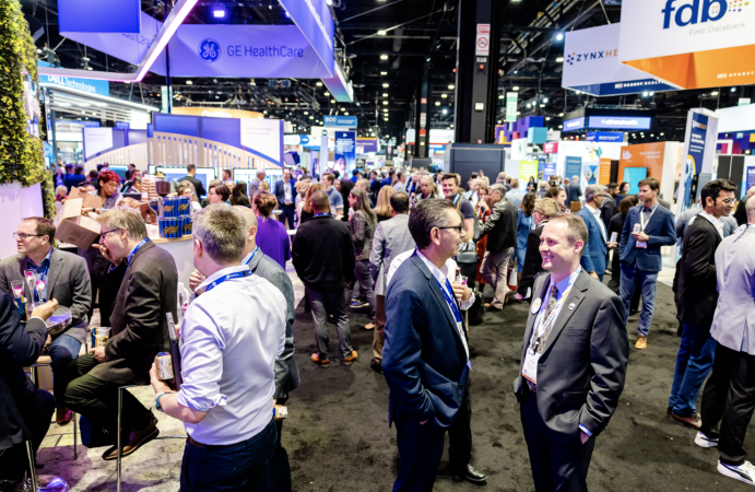 people conversing on the show floor at HIMSS 2023