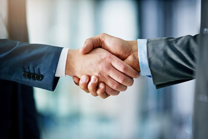 two people shaking hands representing Blackstone's acquisition of Cvent