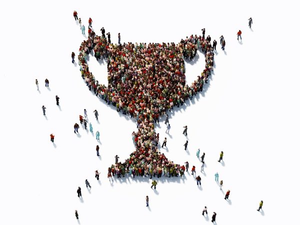 Human crowd forming a big trophy shape on white background. Horizontal  composition with copy space. Clipping path is included. Success and reward concept.